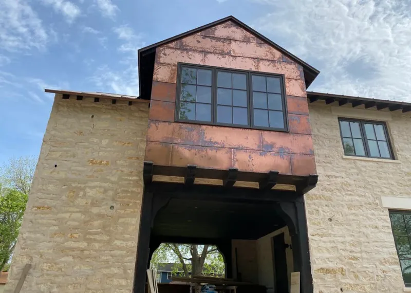 Copper metal panel facade on a stone building for Roof Repair in White Knoll
